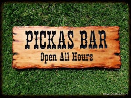 Wooden Bar Sign example using scorched pine and a classic western style font. This sign is stained and finished for indoor use.