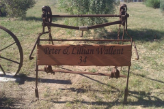 Rustic timber farm sign with property number.