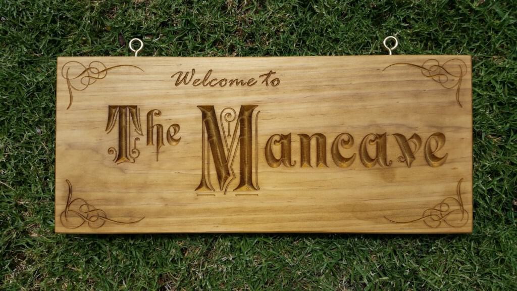 Wooden sign engraved with Welcome to The Mancave