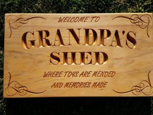 Wooden sign engraved Welcome to Grandpa's Shed where toys are mended and memories made