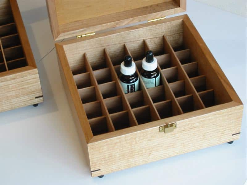 Close up photo of a wooden box with dividers for storing oils bottles