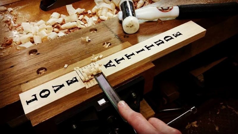 crafting a wooden cross with a chisel and hand tools