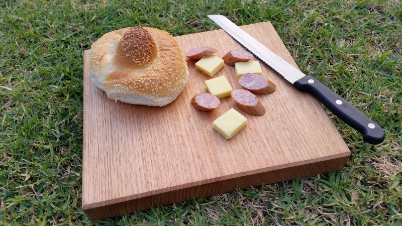 close up of small chopping board with cheese knife and cabana
