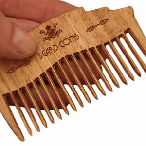 wooden beard comb in hand