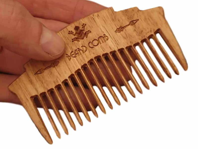 wooden beard comb in hand