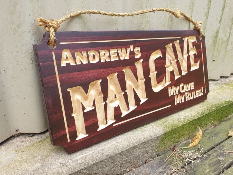 man cave sign Andrews my cave my rules on front of shed angle photo with hemp rope and mahogany stain