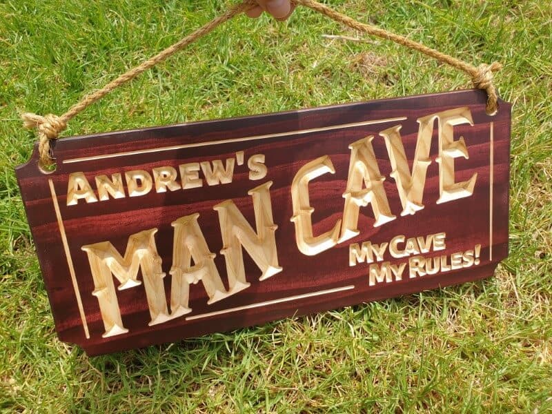 man cave sign Andrews my cave my rules sitting on grass with hemp rope and mahogany stain