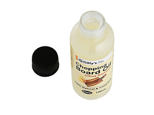 Bottle of chopping board oil with the lid open containing a blend of citrus oils and beeswax.