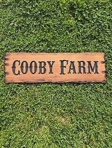 quality cedar farm sign with live edge and rustic carved out lettering in a western style font