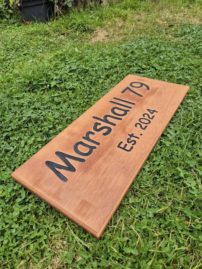 house name sign made from Cedar with carved out lettering painted black showing established date on second line of text