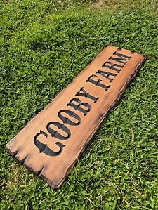 farm name sign with old carved western style font featuring Cedar scorched with flame live edge