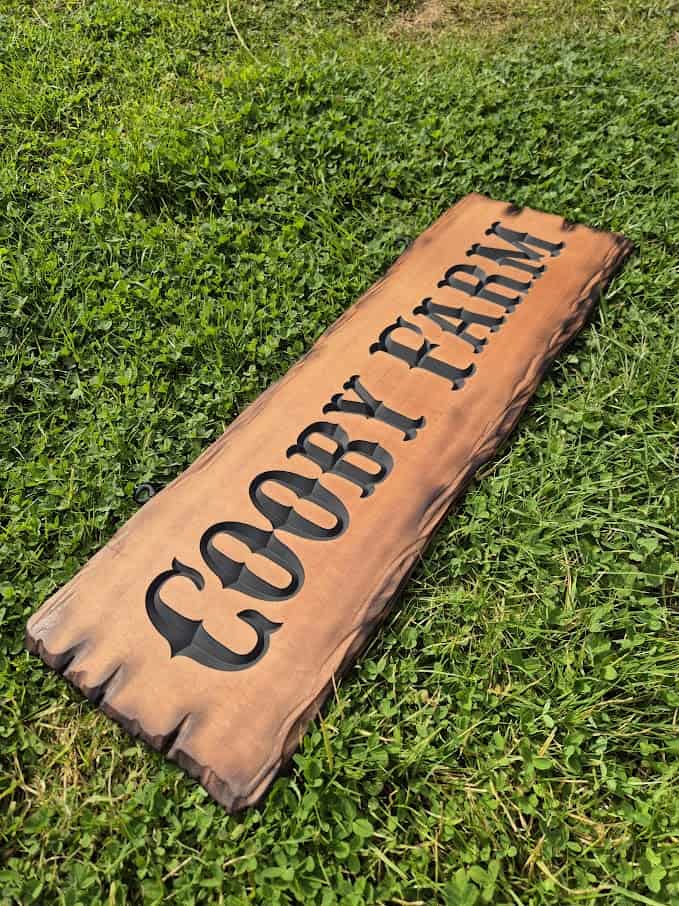 farm name sign with old carved western style font featuring Cedar scorched with flame live edge