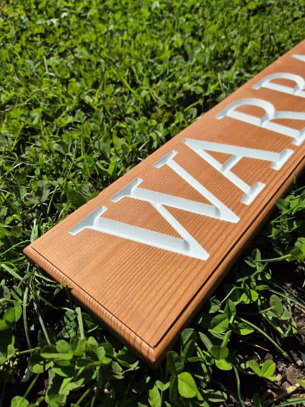 house name sign with white painted carved out lettering on cedar which is the best timber for outdoor use