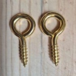 brass plated screw eyes on a rustic wood background