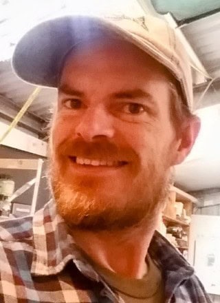 Woodworker Andrew Wilkerson in his workshop with hat on