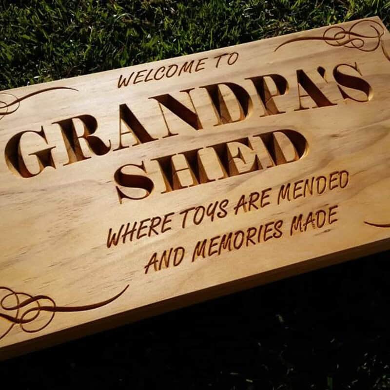 Close up detail of handcrafted Grandpa's Shed wooden sign carving