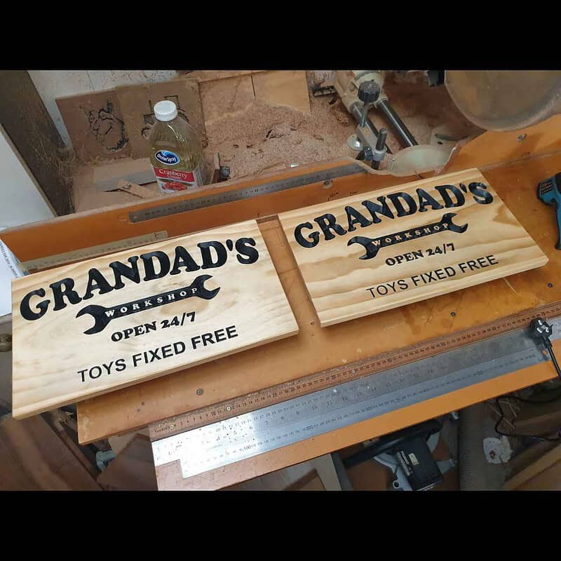 Engraved pine sign with ‘Grandad’s Workshop’ inside a spanner graphic and the text ‘Open 24/7 Toys Fixed Free’ being made in the workshop today.